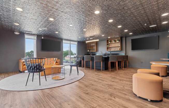 a lounge area with chairs and tables and televisions