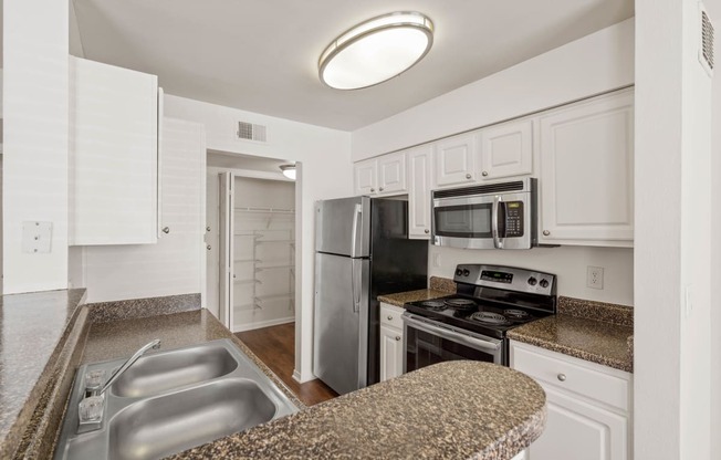 a kitchen with granite countertops and white cabinets