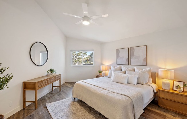 a bedroom with a large bed and a ceiling fan