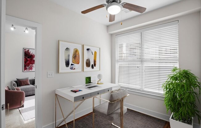 a home office with a ceiling fan and a large window