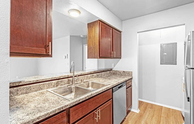 A kitchen with a sink and a refrigerator.