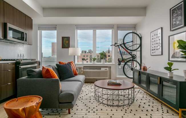 a living room with a couch and a kitchen with a bike on the wall