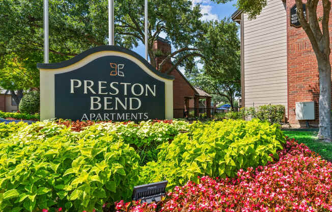 a sign for the presbyterian bend apartments with flowers in front of it