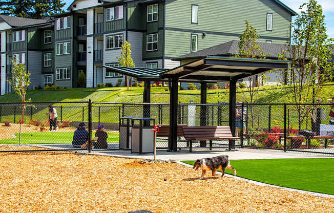 Two people sitting on a bench under a canopy in a park.