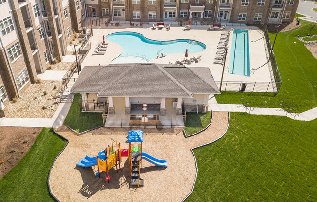 an aerial view of a playground and a pool in an apartment building