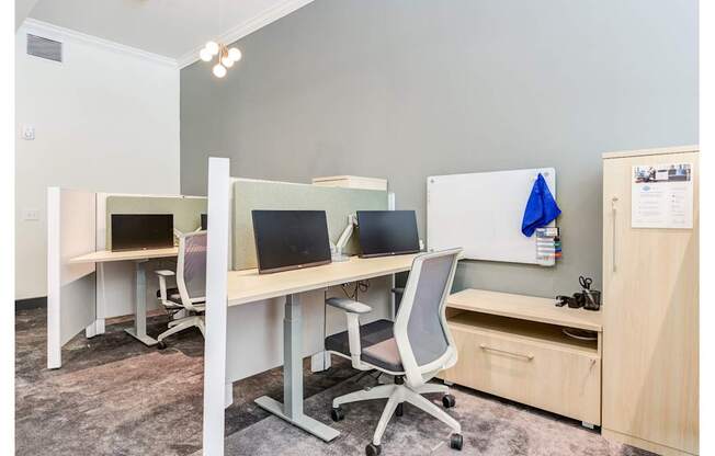 A room with two desks, one with a laptop and the other with a desktop computer.