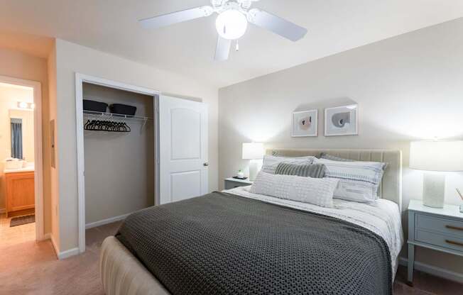 A bedroom with a large bed and a ceiling fan.
