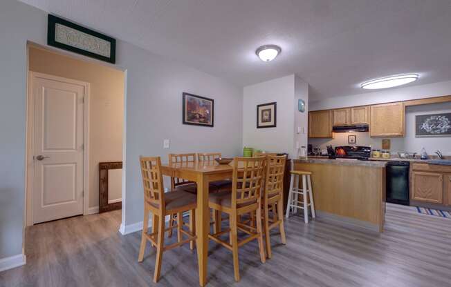 a dining area with a table and chairs and a kitchen