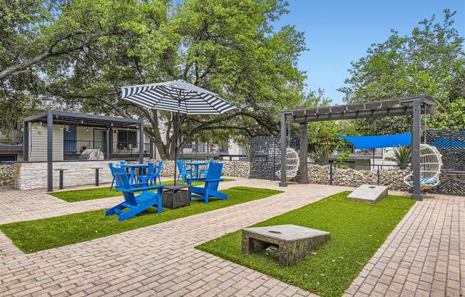a patio with blue chairs and umbrellas and a picnic table
