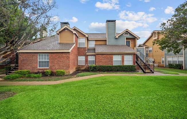 A large house with a green lawn in front.