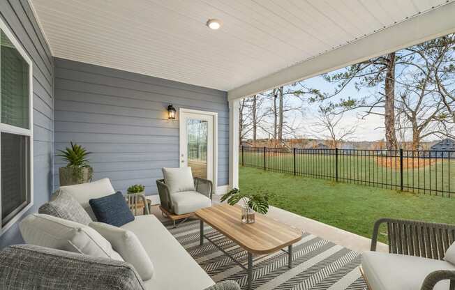a covered porch with couches and chairs and a table