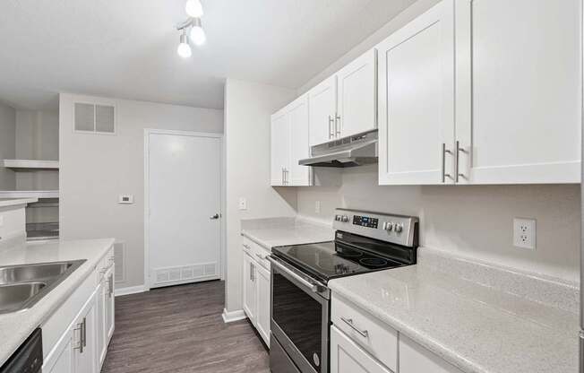 A kitchen with white cabinets and a black stove top oven.
