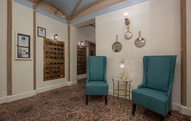 Lobby with two blue cozy chairs, pattered carpeting, detailed moldings, and blue painted ceilings at Stockbridge Apartment Homes, Seattle, Washington