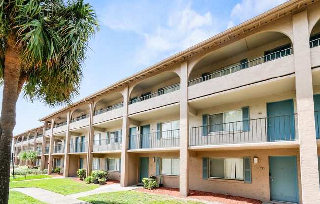 a building with balconies and a palm tree outside of it