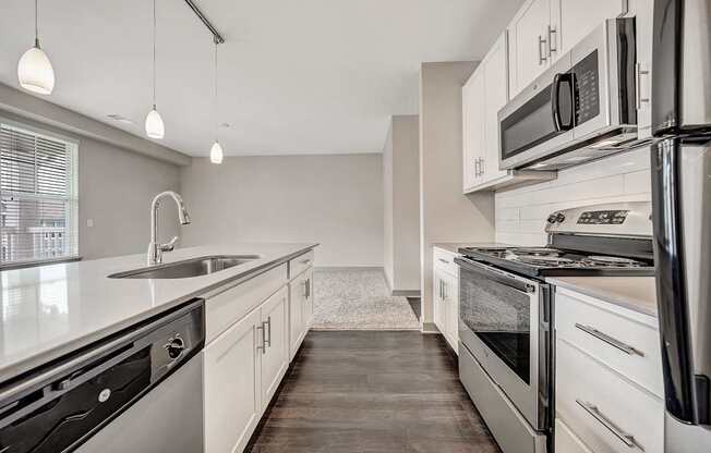 an empty kitchen with white cabinets and stainless steel appliances