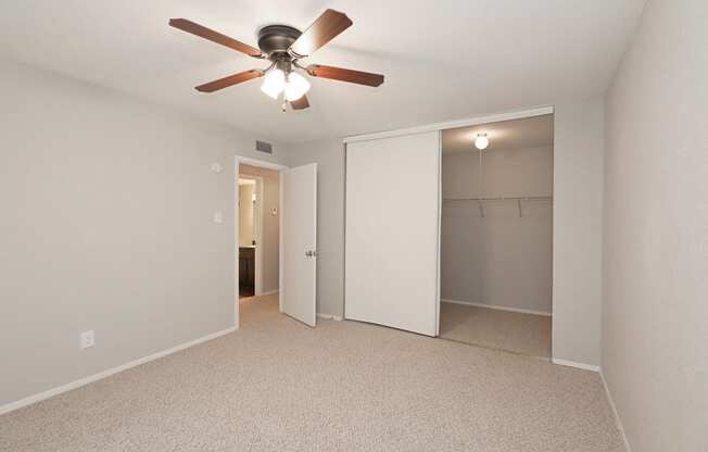 a bedroom with a ceiling fan and closet