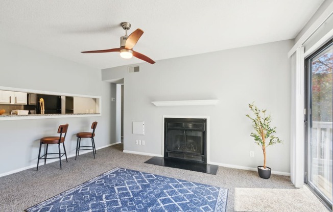 a living room with a fireplace and a ceiling fan