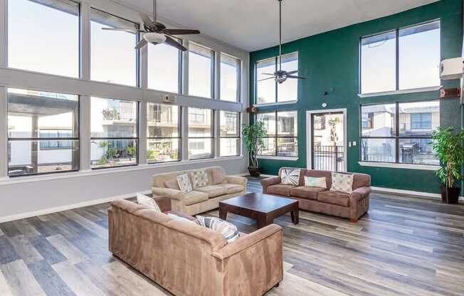 A living room with a large window and a ceiling fan.