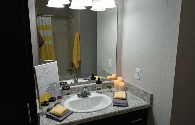 a bathroom with a sink and a mirror and candles