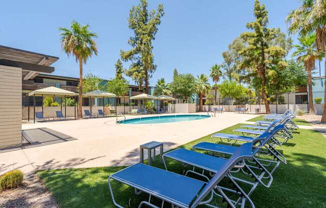 Resort-style pool seating area at Sono Tempe Apartments in Tempe, AZ with shaded loungers and outdoor relaxation space.