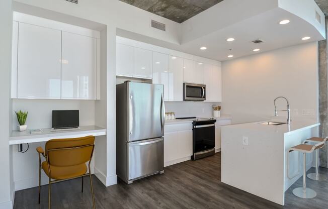 a kitchen with stainless steel appliances and desk