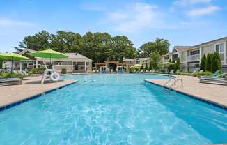 A large swimming pool in a sunny outdoor setting.