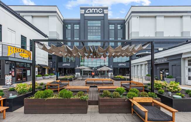 a courtyard with benches and tables in front of a building