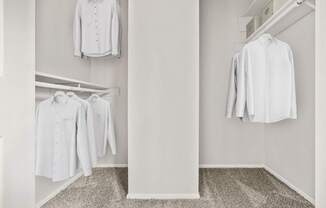 A white shirt hanging on a hanger in a white room.