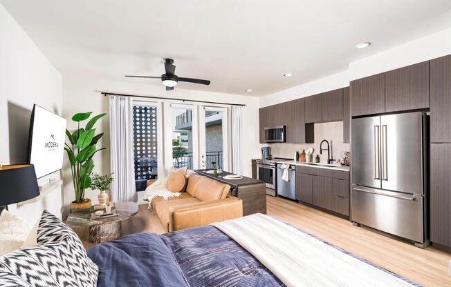 Smartly designed studio layout featuring sleek dark cabinetry, stainless steel appliances, and a private balcony that extends your living space.