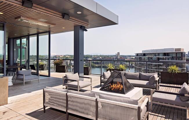 a terrace with couches and a fire pit on a roof top