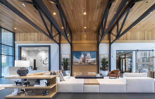 a living room with a large white couch and wooden ceilings