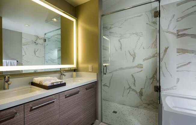 A bathroom with a marble patterned shower door.