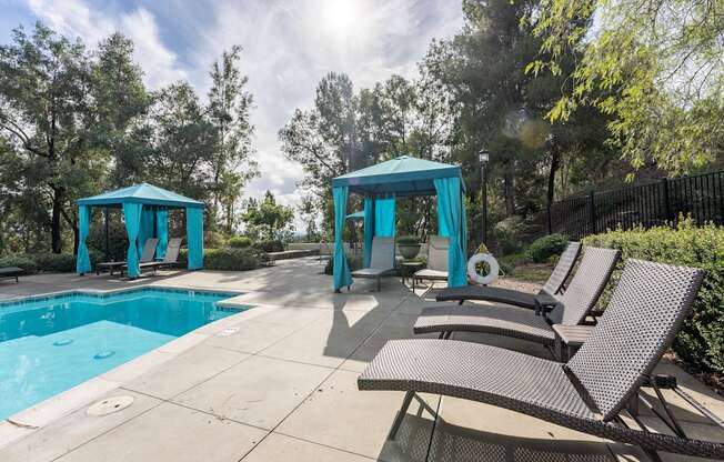 a swimming pool with chairs and umbrellas