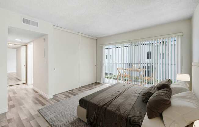 a bedroom with a bed and a sliding glass door