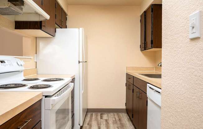 A kitchen with a white stove and refrigerator.