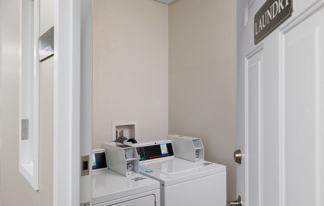 a laundry room with two washers and two washing machines