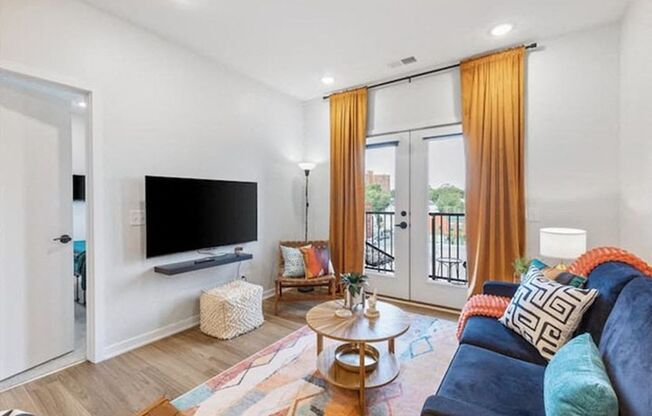 A living room with a blue couch and a flat screen TV.