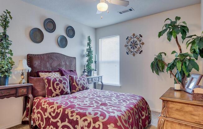 Bedroom with carpet floor, queen size bed, ceiling fan, and window with shades