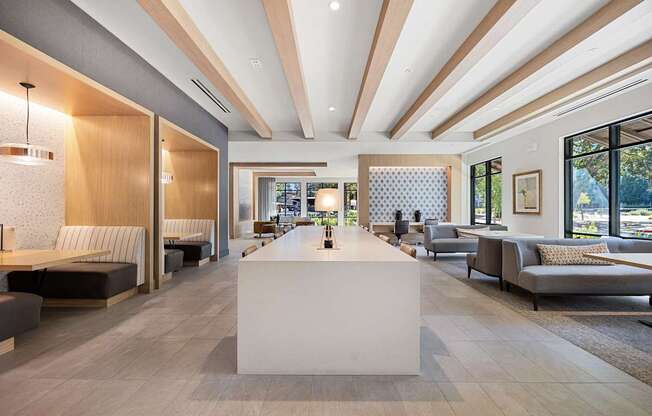 Open lounge with long communal table, semi-private booths, and floor-to-ceiling windows