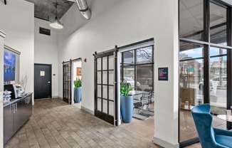 a lobby with glass doors and a table with chairs