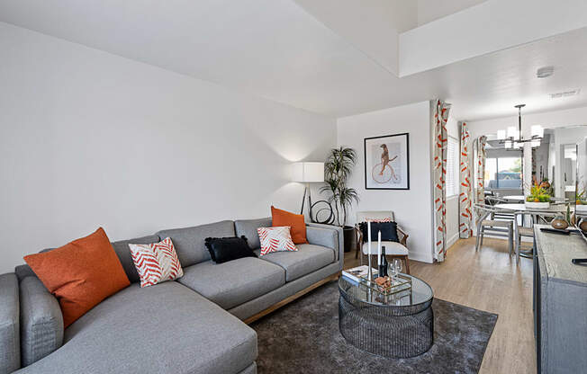 a living room with a gray couch and a glass coffee table