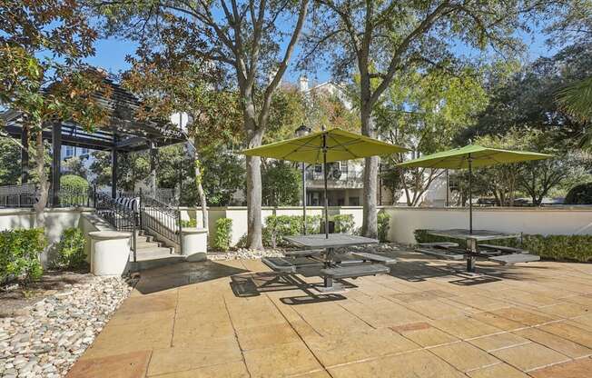 A patio with a table and chairs under umbrellas.