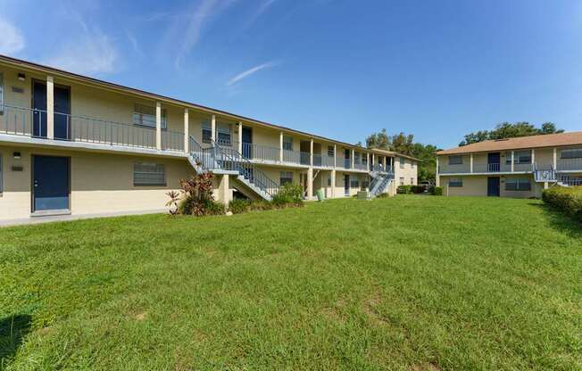 A grassy area in front of apartment buildings.