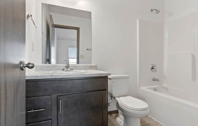 A bathroom with a toilet, sink, and bathtub.