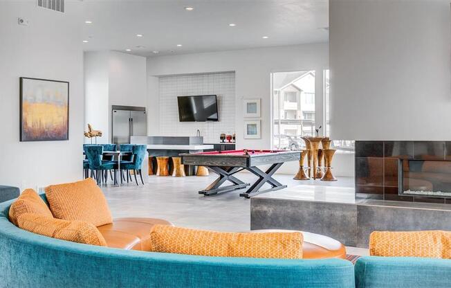 a living room with a ping pong table and a fireplace  at Affinity 56 Apartments in West Jordan, Utah