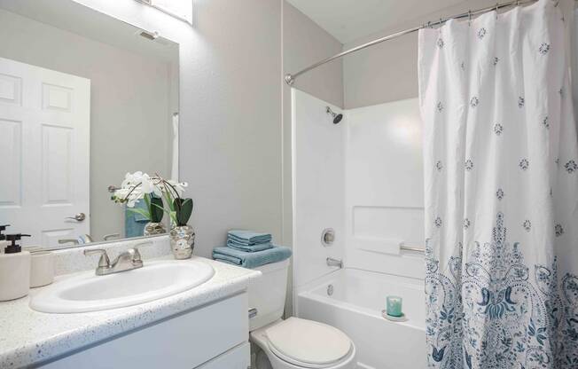 a white bathroom with a shower and a sink and a toilet