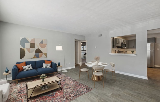A living room with a blue couch and a rug.