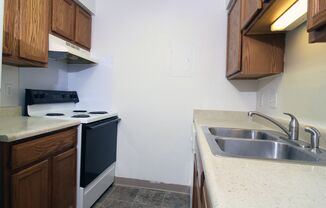 a kitchen with wooden cabinets and a white stove top oven