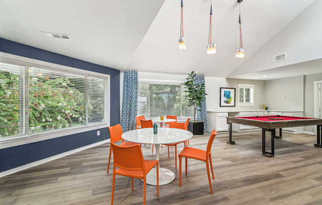 A dining room with a table set for four and a pool table.