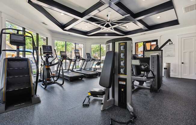A gym with a variety of equipment including treadmills, stationary bikes, and weight machines.